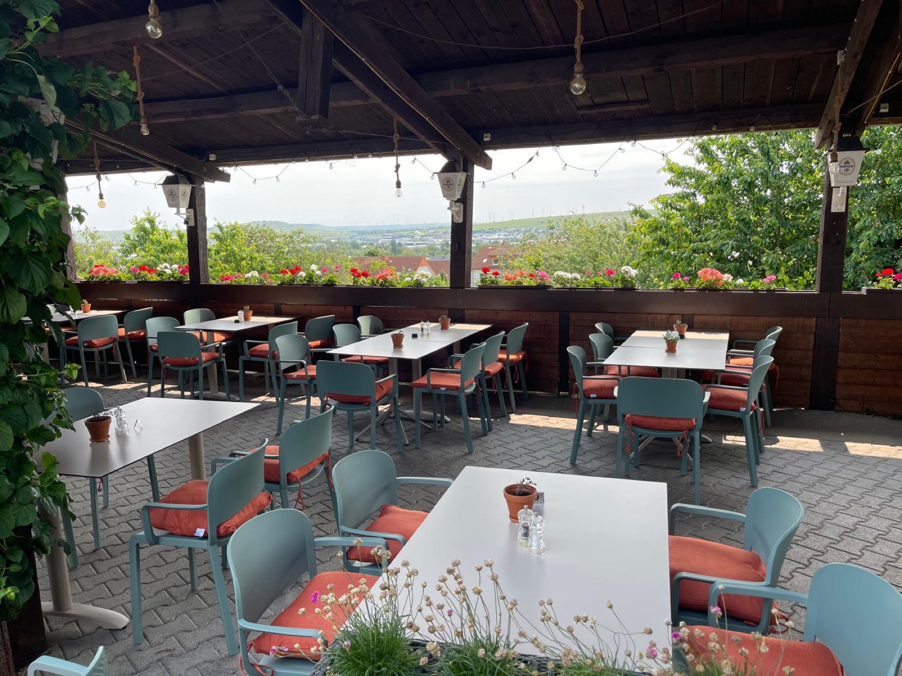 Überdachte Terrasse des Gartenlokals Martinsberg mit Lichterketten und Blick über Bad Kreuznach