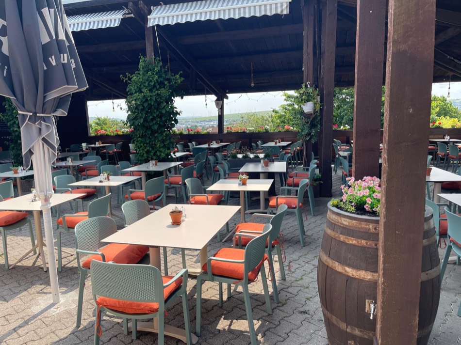 Biergarten mit Sonnenschirmen und Weinfass als Stehtisch